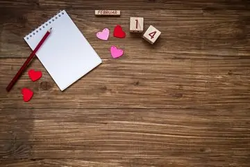 Bloc-notes de la Saint-Valentin sur une table en bois avec des coeurs.