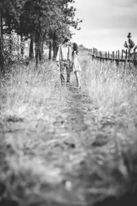 Une photo en noir et blanc d’un couple marchant dans un chemin, capturant l’essence de leur premier rendez-vous amoureux réussi.