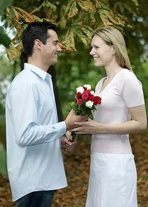 Un homme offre un bouquet de roses à une femme.