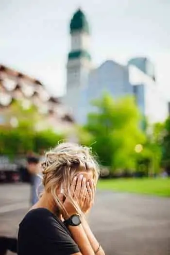 Une femme timide qui trouve l'amour en ligne tout en cachant son visage devant une ville animée.