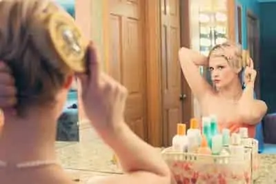 Une femme se prépare pour un premier rendez-vous romantique en se coiffant devant un miroir.