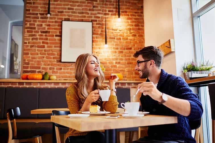 Un homme et une femme assis à une table dans un café.